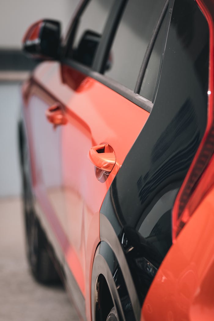 Side of a Red Car with a Black Stripe Above the Rear Wheel